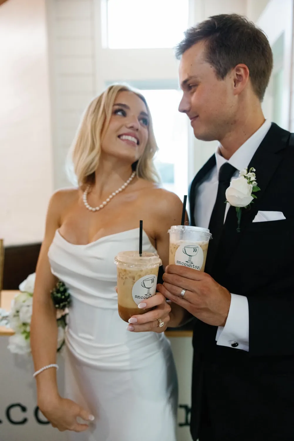Bride and groom holding iced lattes from the Encounter Coffee wedding coffee bar
