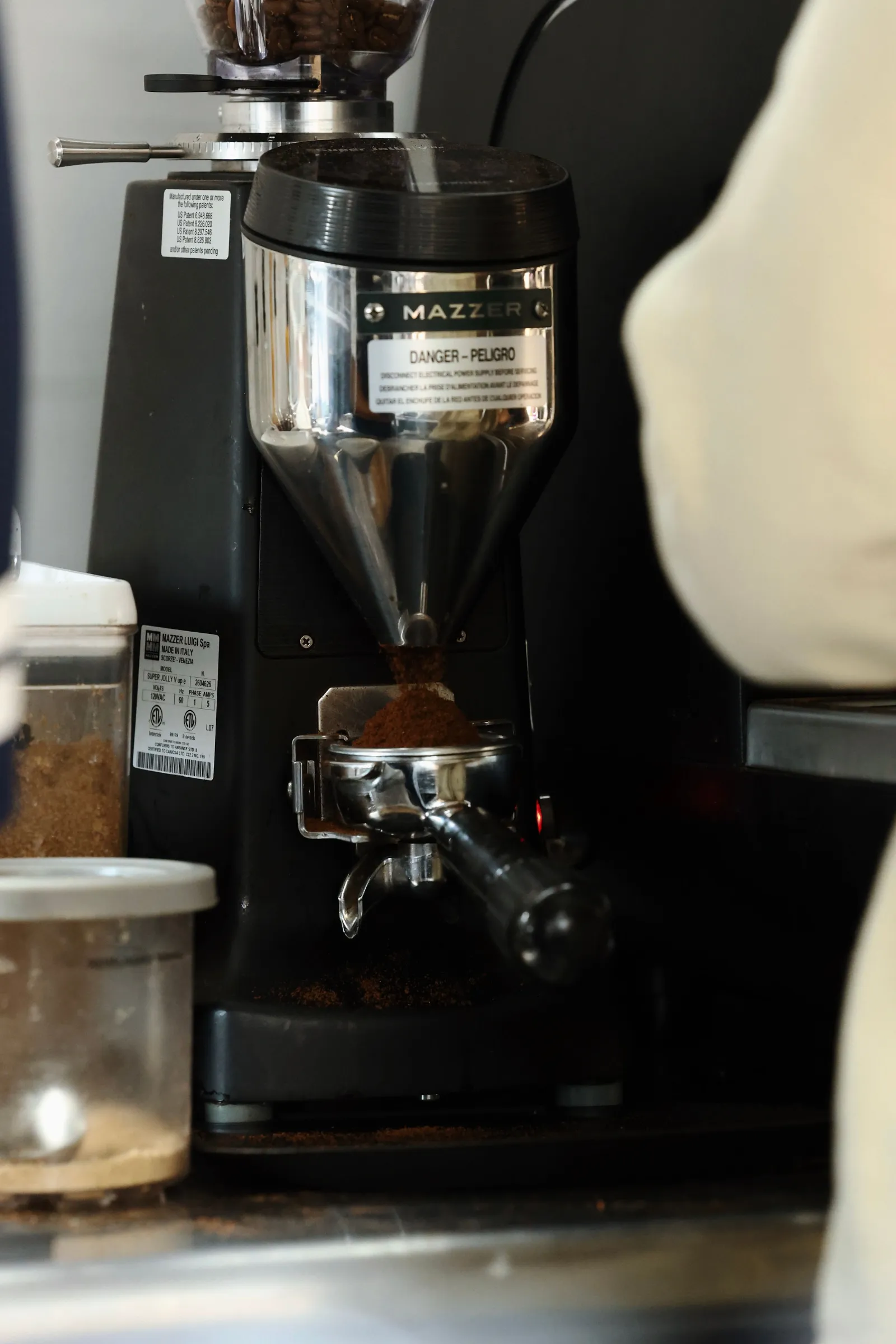 Freshly ground espresso falling into a portafilter from the grinder on the Encounter Coffee bus